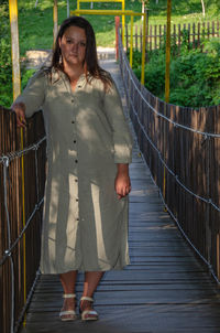 Portrait of smiling woman standing on footbridge