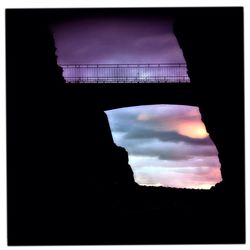 Low angle view of silhouette built structure against cloudy sky