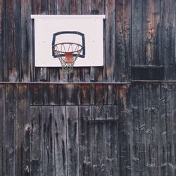 Low angle view of basketball hoop on wooden wall