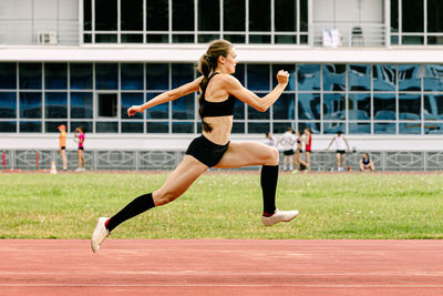 Full length of woman exercising on field