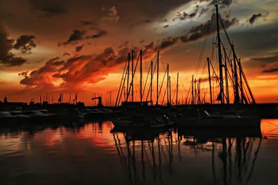 Sailboats moored at harbor