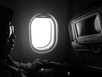 Man wearing sunglasses while sitting in airplane