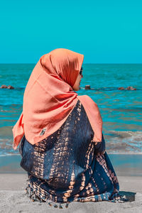 Rear view of woman with umbrella on beach