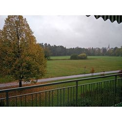 Scenic view of grassy field against cloudy sky