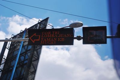 Low angle view of information sign against sky