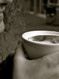 Cropped image of woman having coffee