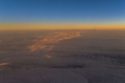 Aerial view of clouds over landscape during sunset