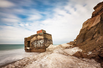 Built structure by sea against sky