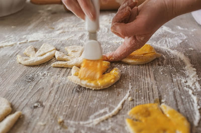 Cropped image of hand making cookies on table