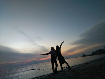 Silhouette of man on beach against sky during sunset