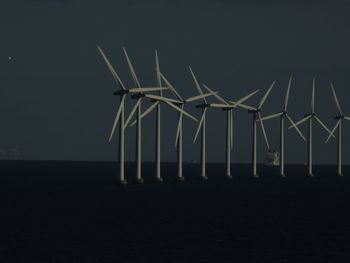 Wind turbines on beach against sky