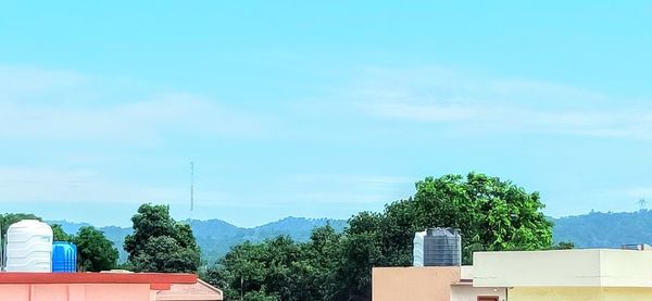 Low angle view of trees and building against sky