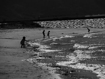 Silhouette people playing on beach