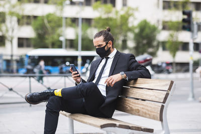 Man using mobile phone while sitting on seat