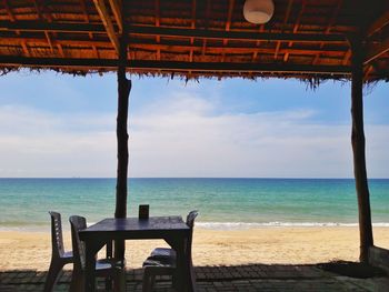 Chairs on beach against sky