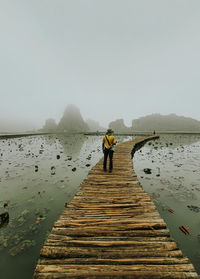 Man standing on lake against sky