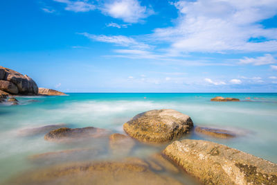 Scenic view of rocks in sea against sky