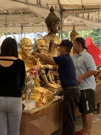 Rear view of people standing outside temple