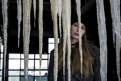 Portrait of a young woman looking through window