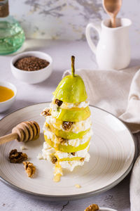 Layers of pear, ricotta with walnut poured with honey on a plate on the table. vitamin nutrition. 