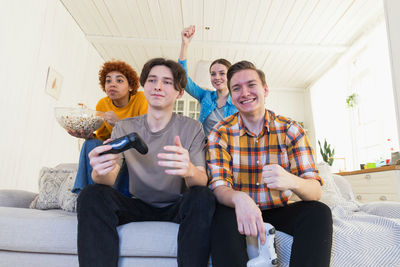 Portrait of smiling family sitting on sofa at home