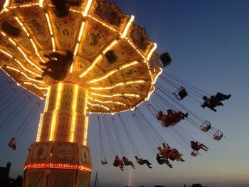 Low angle view of illuminated ferris wheel against sky