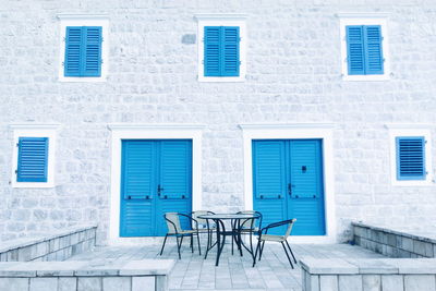 Empty chairs and table against house