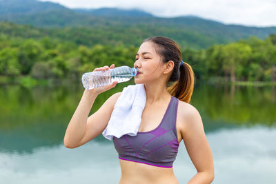 Woman drinking water in lake