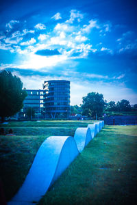 Built structure on field by buildings against sky