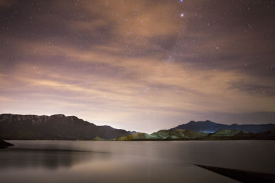 Scenic view of lake against sky at night