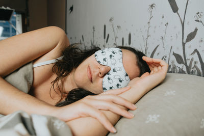 Portrait of woman lying on bed at home