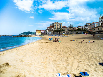 People on beach against buildings in city