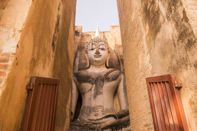 Buddha statue against historic building