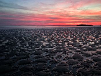 Scenic view of sea against dramatic sky during sunset