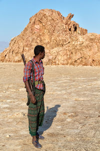 Full length of young man standing on rock