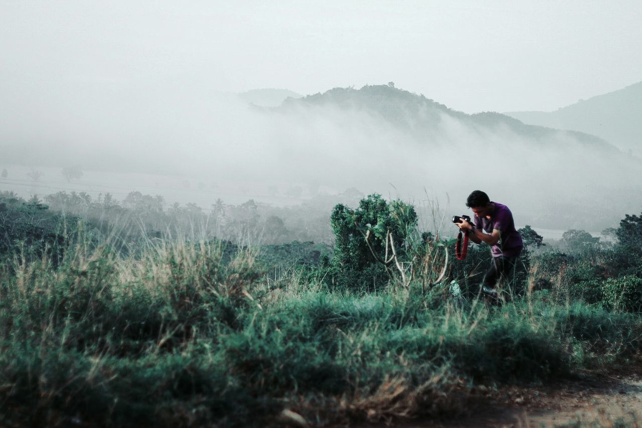 MAN PHOTOGRAPHING ON LAND