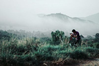 Man photographing in foggy weather