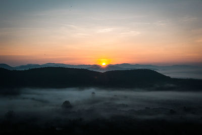 Scenic view of silhouette mountains against sky during sunset