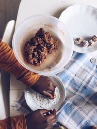 Cropped hand making chocolate cookies at home