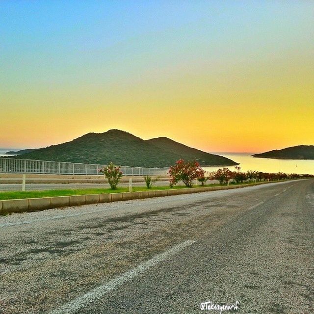 sunset, clear sky, copy space, road, mountain, tranquil scene, tranquility, scenics, transportation, landscape, beauty in nature, the way forward, nature, mountain range, orange color, sky, water, sand, street, outdoors