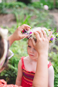 Low section of woman holding flower on plant