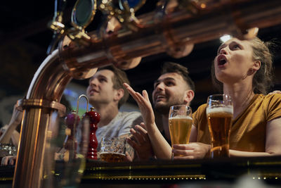 Happy friends watching soccer match at bar