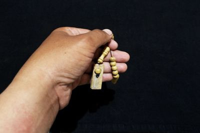 Midsection of person holding ice cream against black background