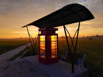 Built structure on field against sky during sunset