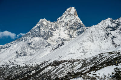 Scenic view of snowcapped mountains against clear blue sky