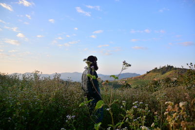 Man standing on field against sky