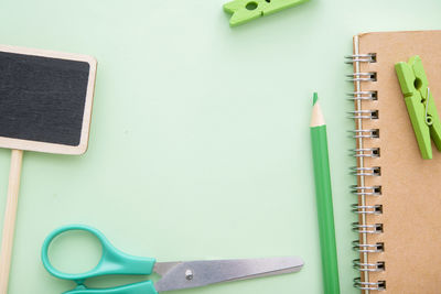 Directly above shot of office supplies on green background