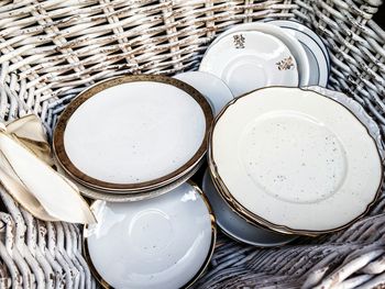 High angle view of ceramics plates in wicker basket