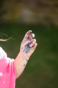 Cropped hand of girl with paint stains
