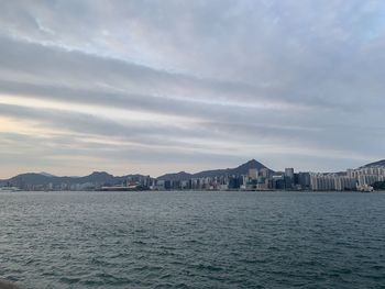 Sea by buildings against sky